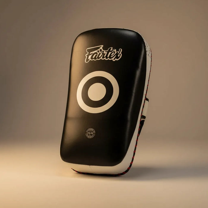 Pao Fairtex curved kick pad en studio sur fond gris chaud
